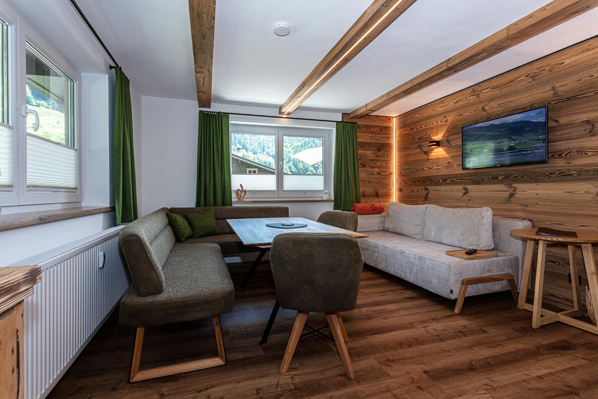 Wohn- und Essbereich der Klamm Lodge mit Altholzwand