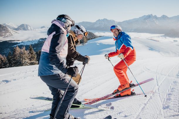 Skilehrer mit Gästen im Wintersportgebiet