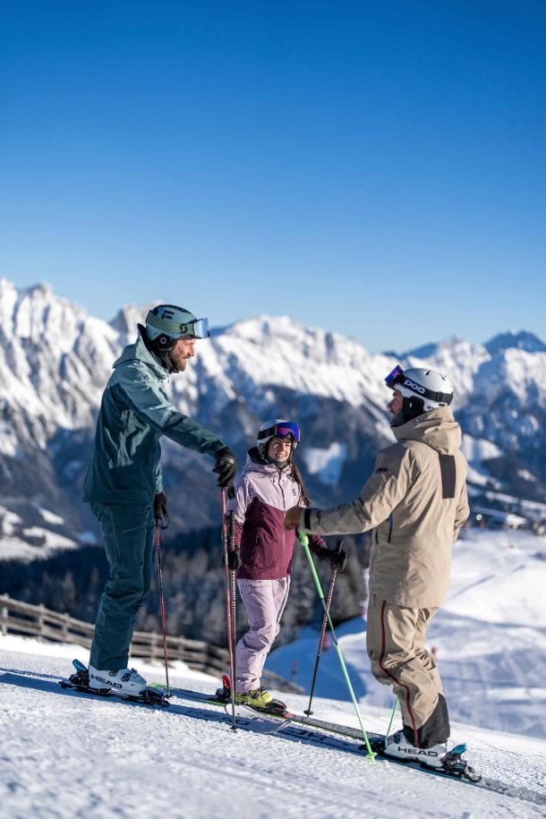 Wintersportler vor der Bergkulisse der Leoganger Steinberge
