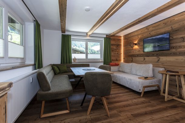 Wohn- und Essbereich der Klamm Lodge mit Altholzwand