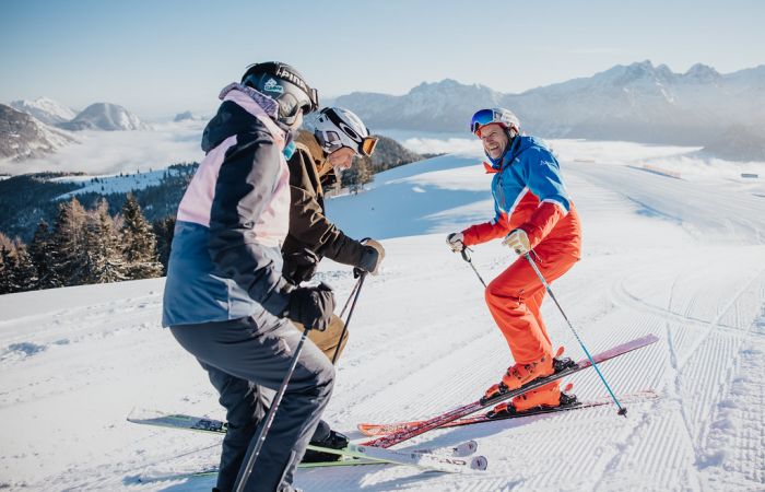 Skilehrer mit Gästen im Wintersportgebiet
